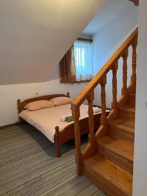 a bedroom with a bed next to a staircase at Pansion Tomas Kupres in Kupres