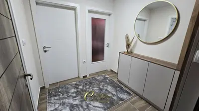 a hallway with a mirror and a dressing room at Carpe Diem Spa Apartman in Teslić