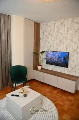a living room with a television on a wall at Carpe Diem Spa Apartman in Teslić