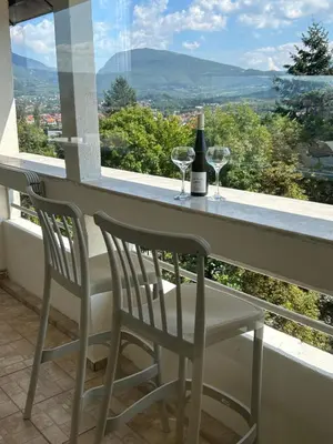 a table with two glasses and a bottle of wine at Stan na dan Kalin in Bugojno