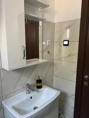 a white bathroom with a sink and a mirror at Apartment Lana Vareš in Vareš