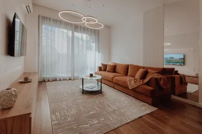 a living room with a brown couch and a table at BLuxe Residence in Banja Luka
