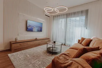 a living room with a couch and a large window at BLuxe Residence in Banja Luka
