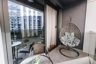 a room with a balcony with chairs and a table at BLuxe Residence in Banja Luka