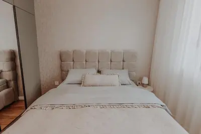 a bedroom with a large bed with a large headboard at BLuxe Residence in Banja Luka