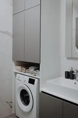 a white kitchen with a washing machine and a counter at BLuxe Residence in Banja Luka