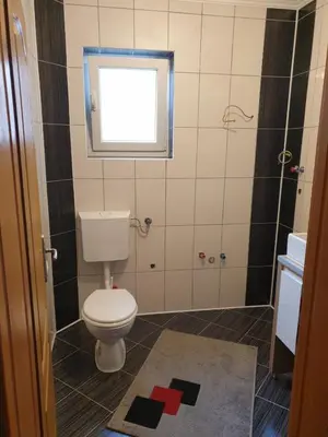 a small bathroom with a toilet and a window at Villa Big Mama in Živinice