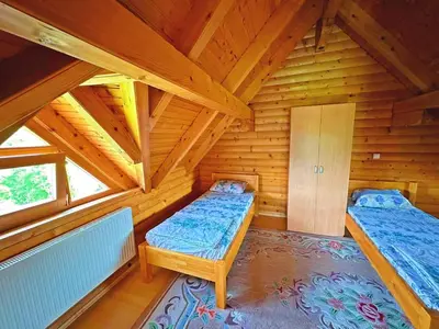 a bedroom with two beds in a wooden cabin at Vikendica sa bazenom Cazin Pecigrad in Cazin