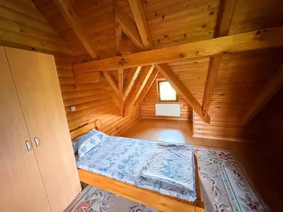 a room with a bed in a wooden cabin at Vikendica sa bazenom Cazin Pecigrad in Cazin