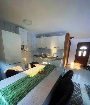a kitchen with a table with a green arrangement on it at Vikendica sa bazenom Cazin Pecigrad in Cazin