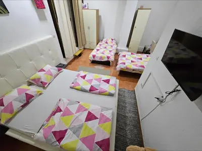 a room with two beds with pillows and a mirror at Lira Apartmani in Prnjavor