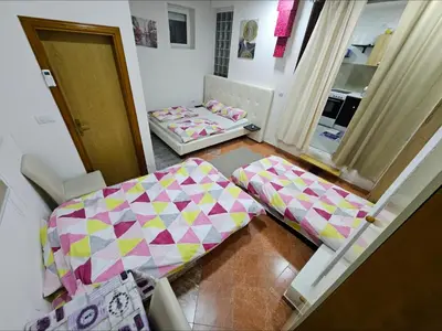 a small room with a bed and a table at Lira Apartmani in Prnjavor