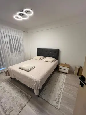 a bedroom with a large bed with a black headboard at Stan na dan TowerLife Gradačac in Gradačac