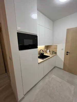 a white kitchen with a sink and a microwave at Stan na dan TowerLife Gradačac in Gradačac