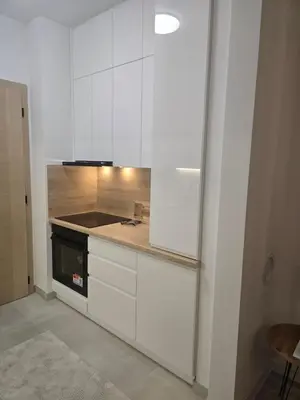 a kitchen with white cabinets and a stove at Stan na dan TowerLife Gradačac in Gradačac