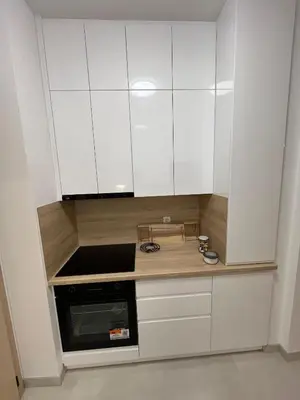 a kitchen with white cabinets and a stove at Stan na dan TowerLife Gradačac in Gradačac