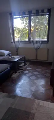 a living room with a table and a window at Apartman Jelena Lux in Doboj