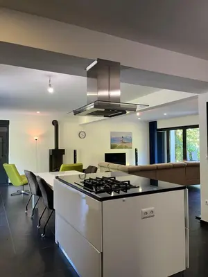 a kitchen with a stove top oven next to a living room at Villa Bukvic in Zavidovići
