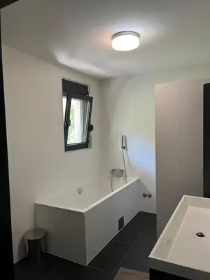 a white bathroom with a tub and a sink at Villa Bukvic in Zavidovići