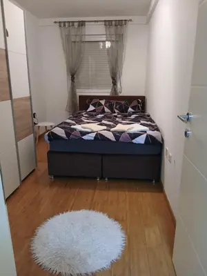 a bedroom with a bed and a white rug at Apartman Čakarević in Doboj