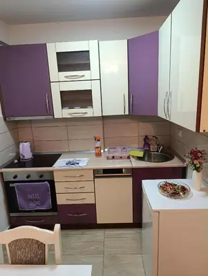 a kitchen with purple and white cabinets and a sink at Apartman Čakarević in Doboj