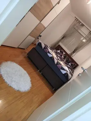 an attic bedroom with a bed and a white rug at Apartman Čakarević in Doboj