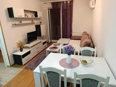 a living room with a dining table and a living room with a couch at Apartman Čakarević in Doboj
