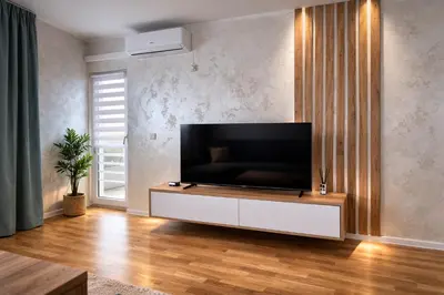 a living room with a flat screen tv on a wall at Hari Apartmani Oaza in Tuzla
