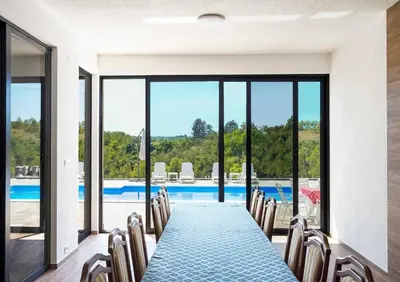 a dining room with a table and chairs and a pool at Dream House Banja Luka in Banja Luka