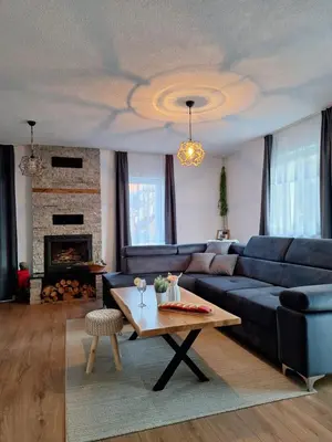 a living room with a blue couch and a table at Vikendica VIA - Čajuša, Kupres in Kupres