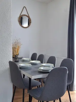 a dining room with a table with chairs and a mirror at Vikendica VIA - Čajuša, Kupres in Kupres