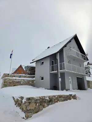 a house in the snow with a rock at Vikendica VIA - Čajuša, Kupres in Kupres