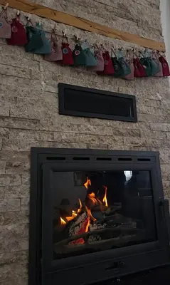 a fireplace with christmas ornaments hanging on a wall at Vikendica VIA - Čajuša, Kupres in Kupres
