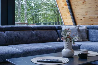 a living room with a blue couch and a table at Golf Forest Creek Villas in Zavidovići