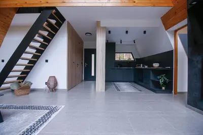 a living room with a staircase in a house at Golf Forest Creek Villas in Zavidovići