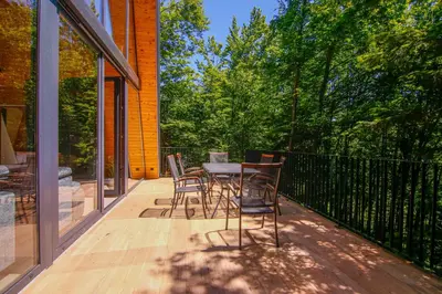 a patio with chairs and a table on a deck at Golf Forest Creek Villas in Zavidovići