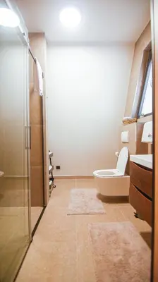 a bathroom with a toilet and a sink and a shower at Golf Forest Creek Villas in Zavidovići