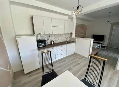 a kitchen with white cabinets and a table and chairs at Villa Lilak in Bihać