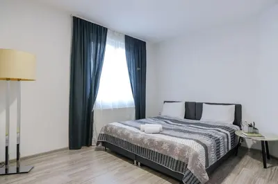a bedroom with a bed and a large window at 3D Caffe Apartmani in Visoko
