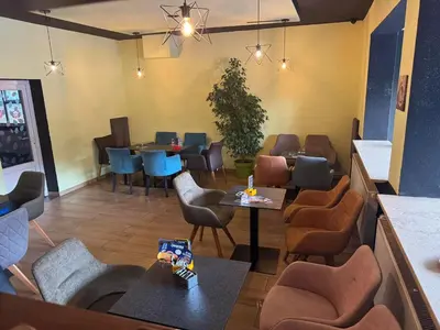 a restaurant with chairs and tables in a room at 3D Caffe Apartmani in Visoko