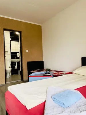 a bedroom with a bed and a bathroom with a sink at 3D Caffe Apartmani in Visoko