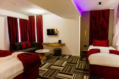 a hotel room with two beds and a couch at PARK INN, Bugojno in Bugojno
