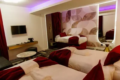 a hotel room with three beds and a tv at PARK INN, Bugojno in Bugojno