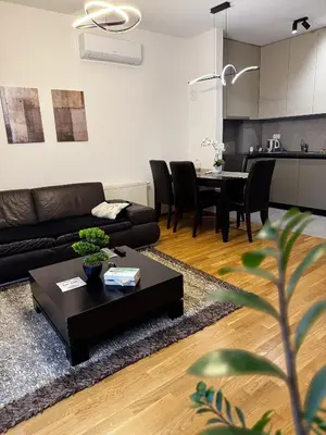 a living room with a black couch and a table at Urban Suite BL Apartment in Banja Luka