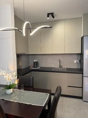 a kitchen with a table and a kitchen with white cabinets at Urban Suite BL Apartment in Banja Luka