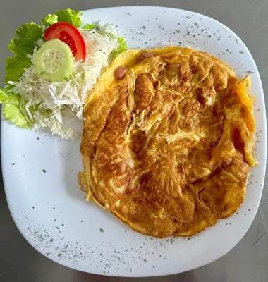 a white plate with a omelet and a salad at Prenoćište Vozač in Jajce