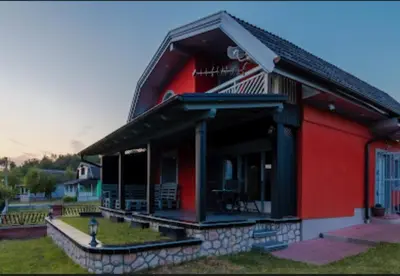 a red house with a black roof at Vienna Rem in Lukavac