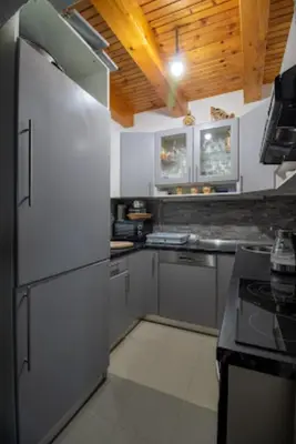 a kitchen with a white refrigerator and a stove at Vienna Rem in Lukavac