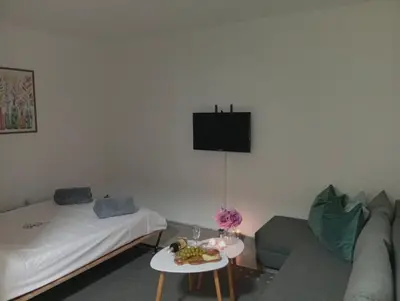 a living room with a couch and a tv on the wall at Apartman Mali kutak in Gradačac