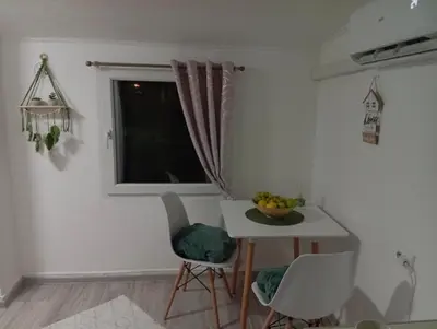 a small kitchen with a table and a window at Apartman Mali kutak in Gradačac